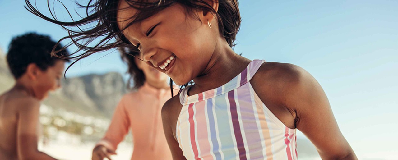 Little girl running around in a bathing suit 
