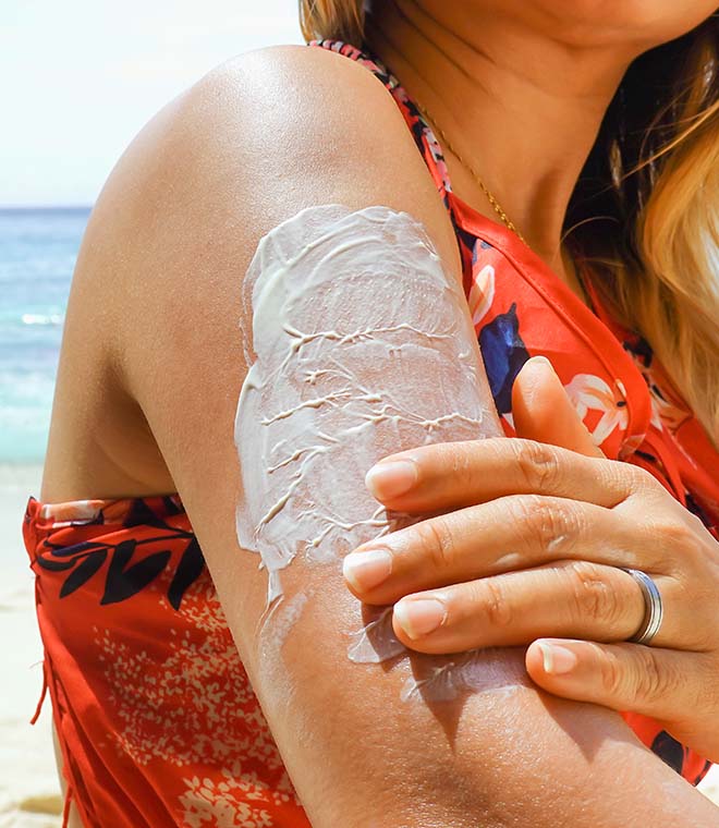 Woman applying sunscreen on the beach