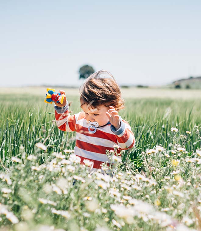 Little boy running through the grass