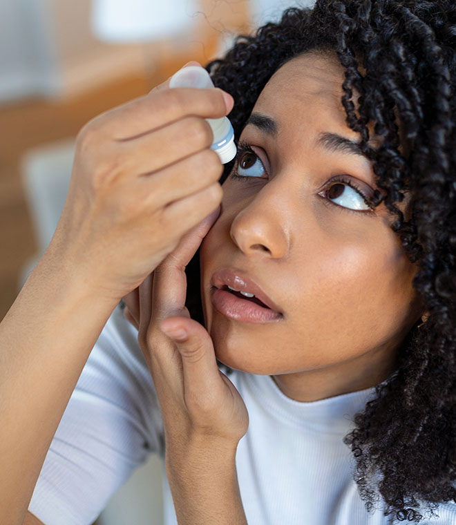 Young woman using eye drops