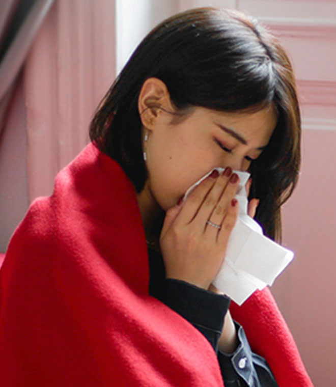 Young Asian woman blowing her nose