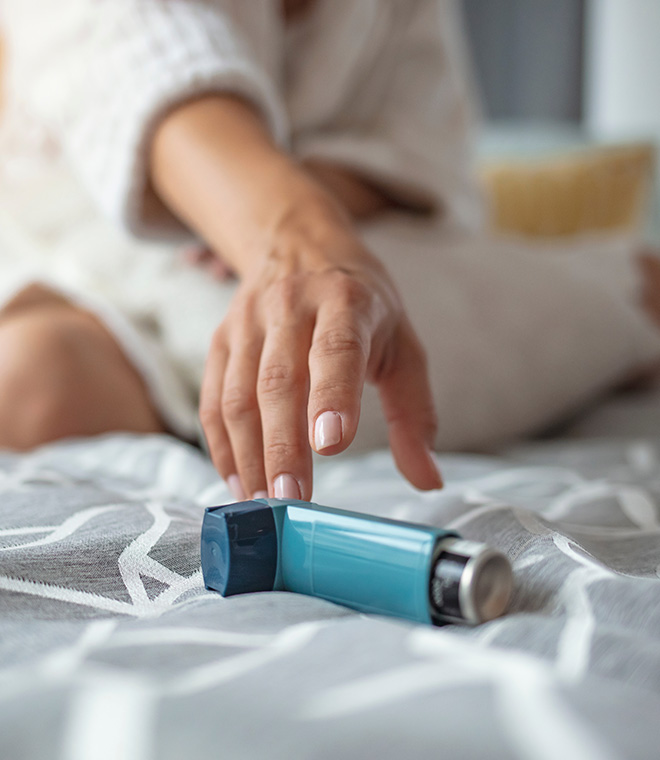 Female hand reaching towards an inhaler