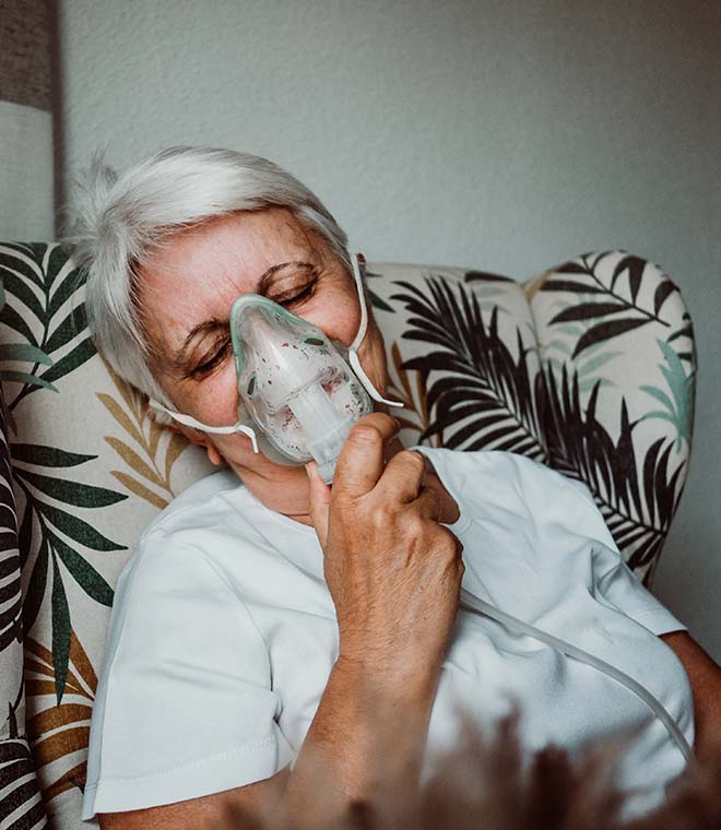 Older woman using a breathing treatment