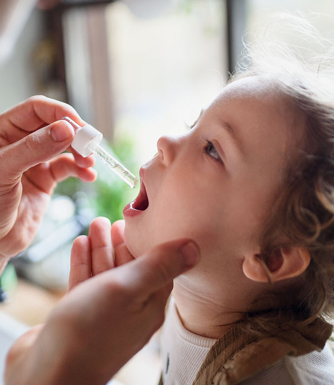 Toddler taking medicine from a dropper