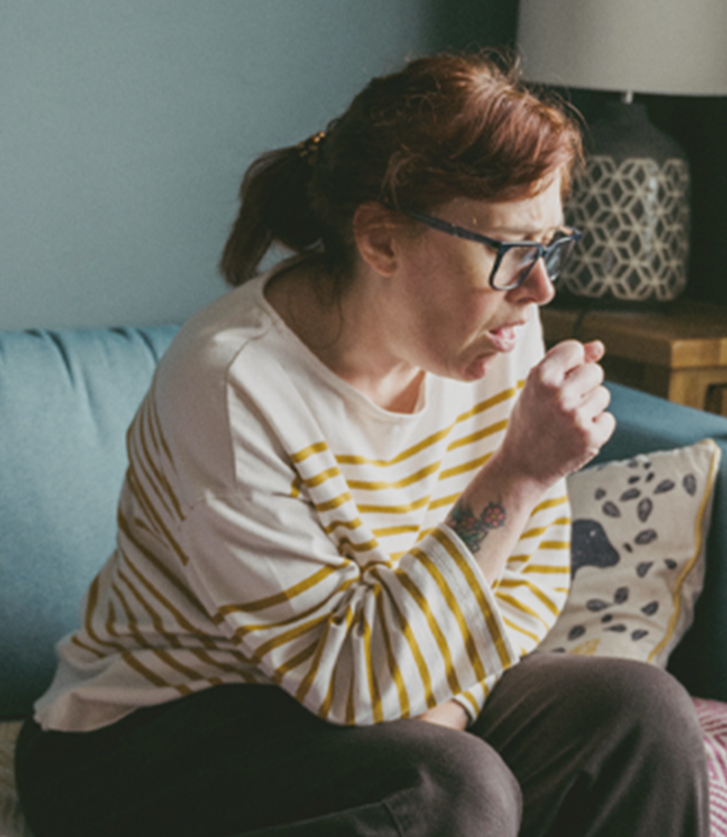 Woman in a yellow shirt coughing