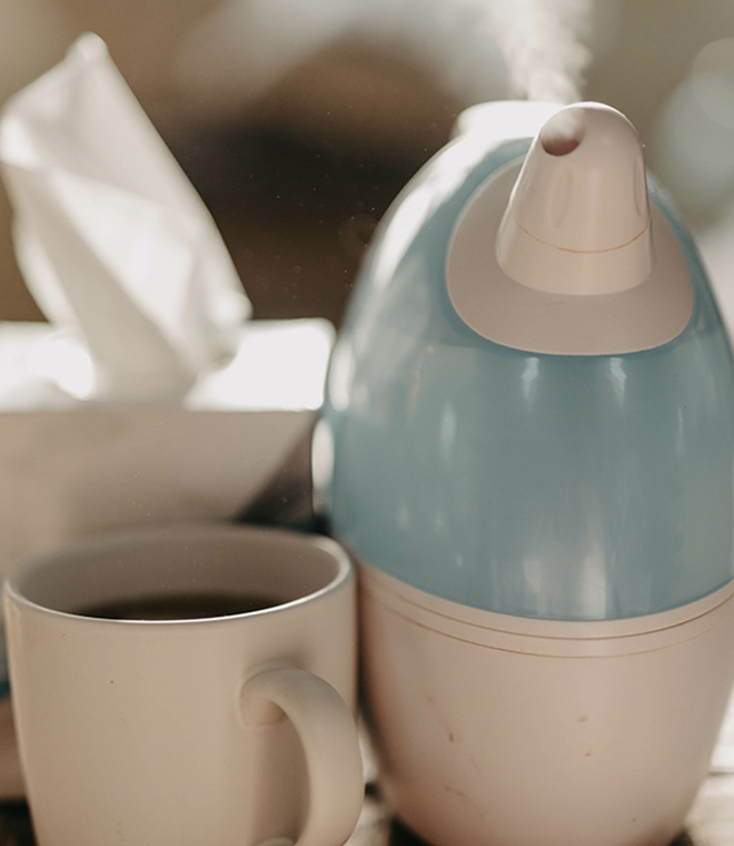 Humidifier next to a cup and box of tissues