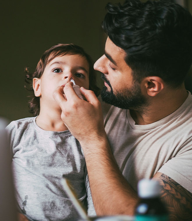 Man giving medicine to young child