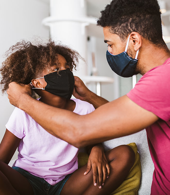 Dad putting a mask on his young son