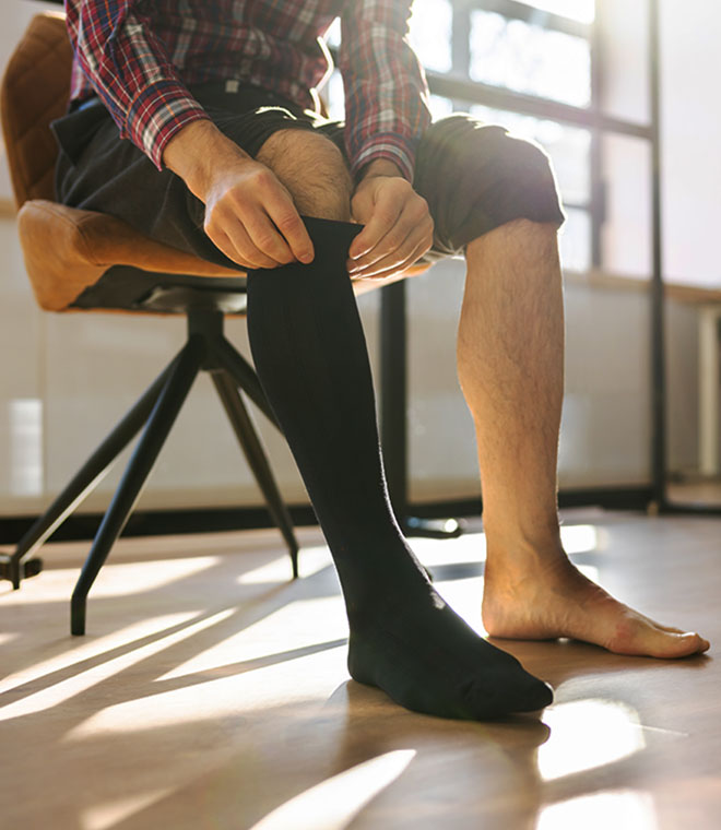 Man putting on a black sock