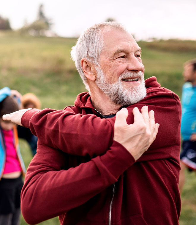 Man with gray beard stretching