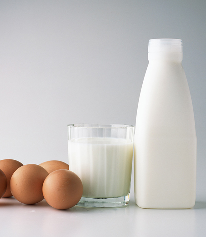 Brown eggs and glass of milk on table