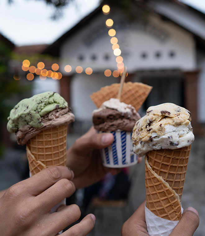 Hands holding up ice cream cones