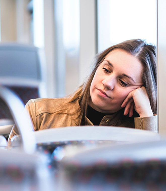 Young white woman on bus leaning against window