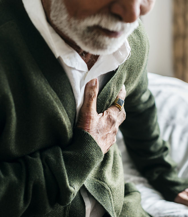 Elderly black man clenching his chest