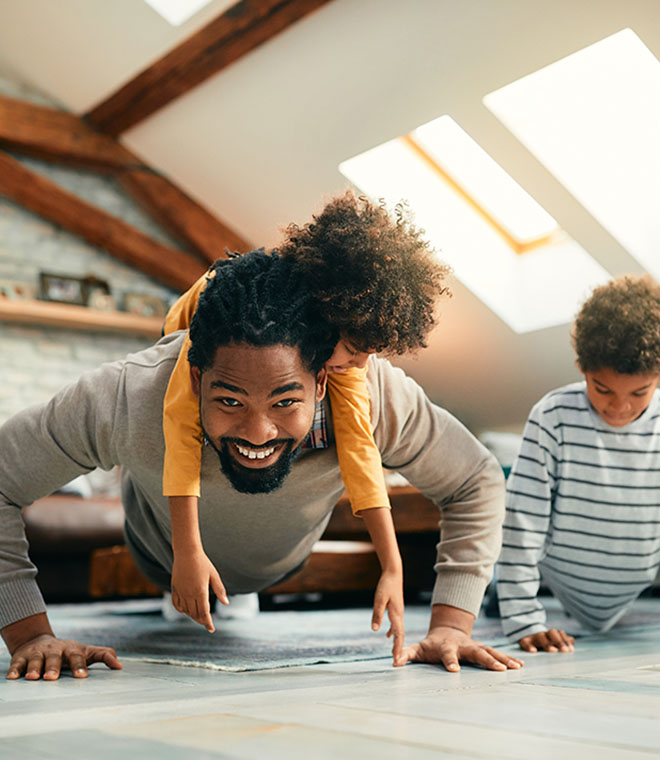 Young black father exercising with his children