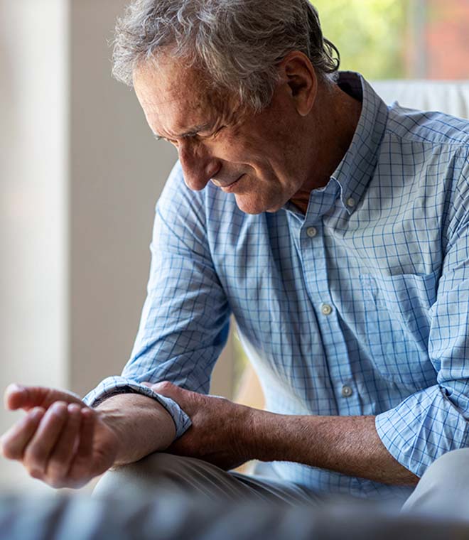 Older white man holding his arm in pain