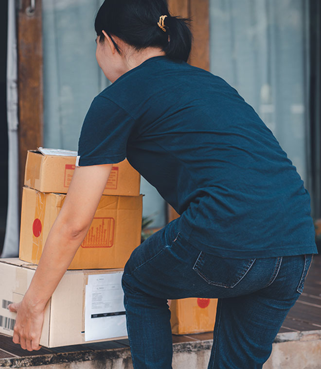 Woman lifting heavy boxes