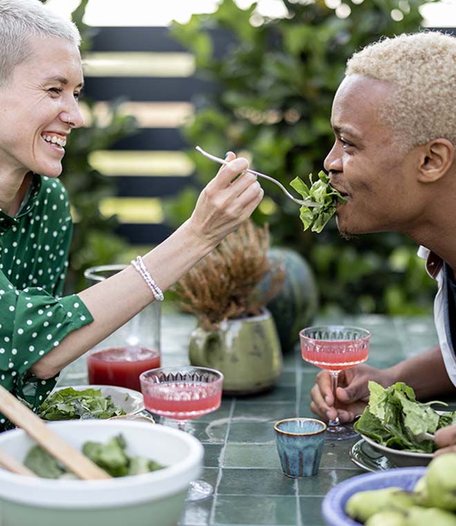 Interracial couple in their 30s sharing a salad