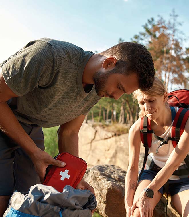 Man pulling a first aid kit out of a bag