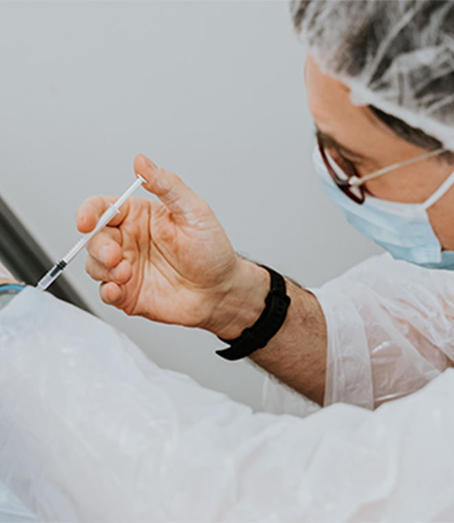 A Photo of a man giving a shot to patient - Click for more info