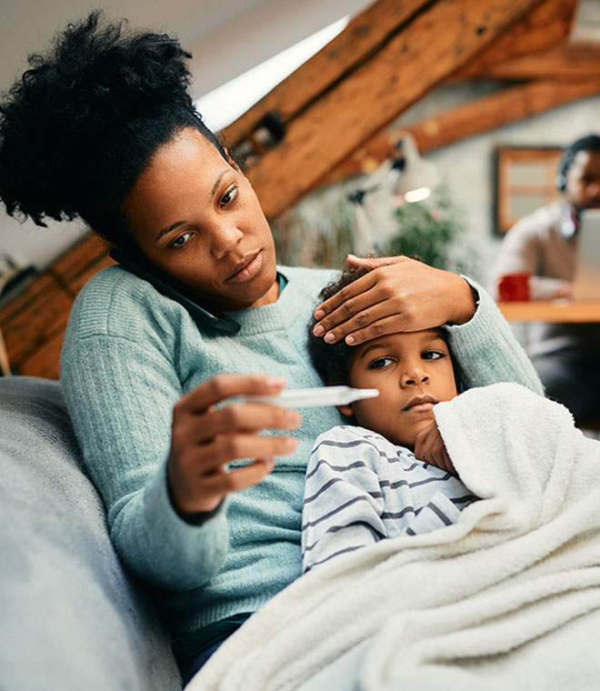 Young black mother taking her sons temperature