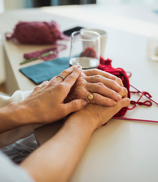 White woman holding hand of older person