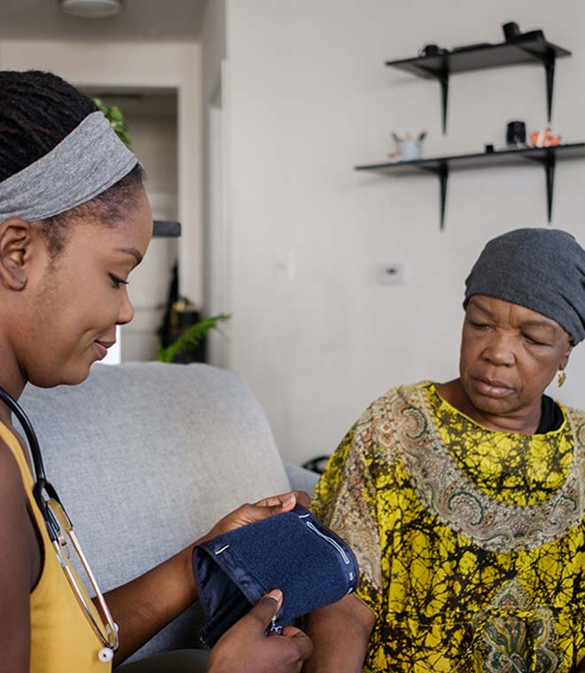 Woman checking her mother's blood pressure