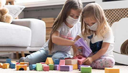 Little girls playing with building blocks