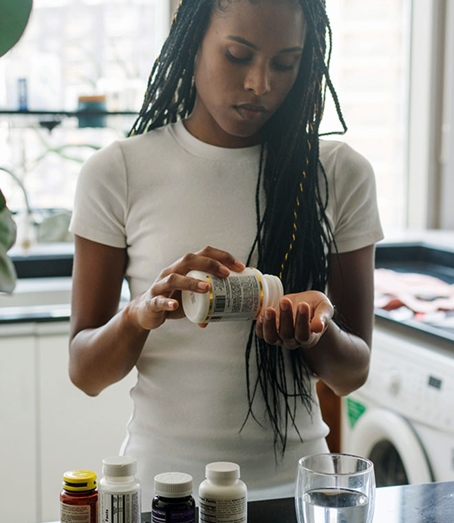 Woman pouring medicine from pill bottle into her hand