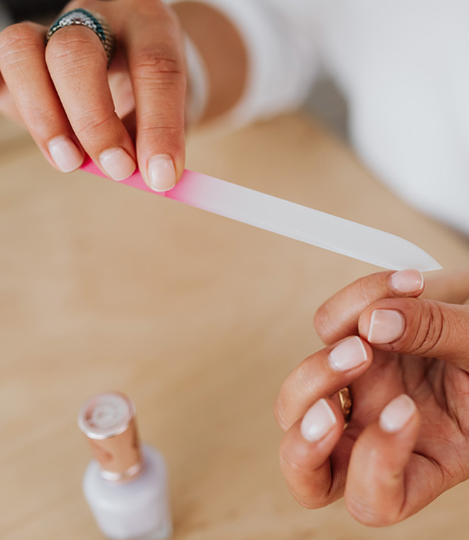 Woman at table filing her nails