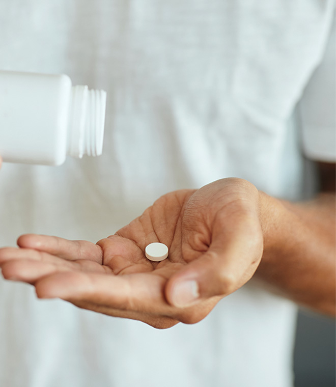 Man pouring a pill into his hand